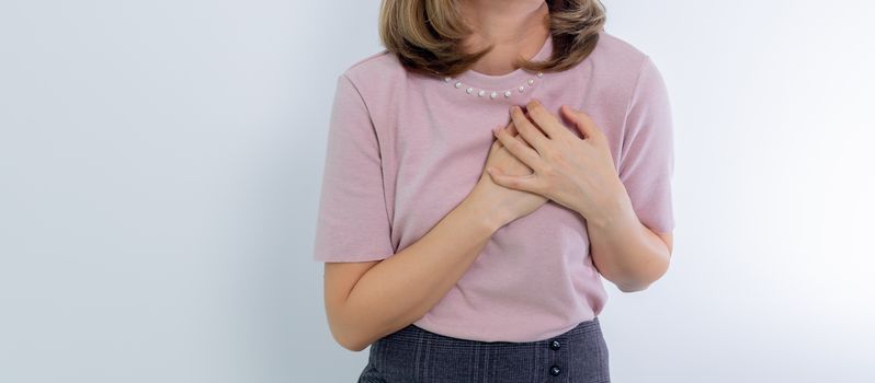 A woman holds her chest conveying emotion or heartache.