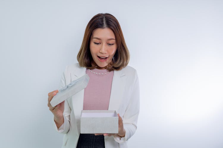 Woman In White Blazer Opening A Gift