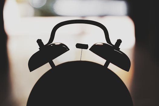 Silhouette of a vintage analogue alarm clock, artistic close-up.