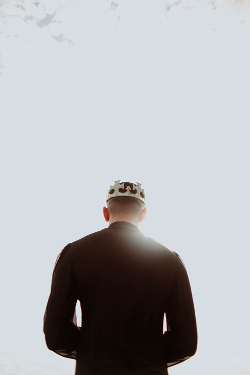 Free A man in a crown and black sweater stands against bright sunlight in Rio de Janeiro. Stock Photo