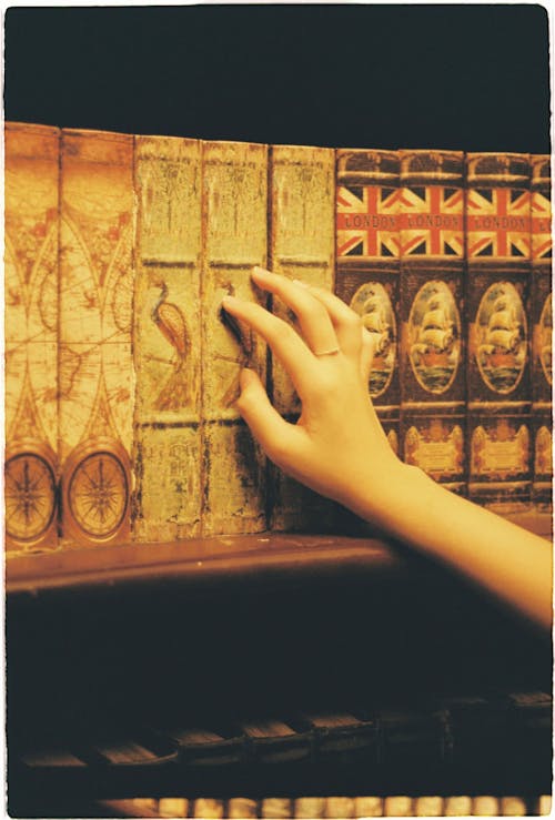 Person's Hand on Ancient Books 