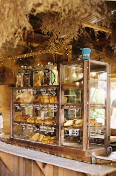 Wooden bakery counter showcasing a variety of fresh breads and pastries in a rustic setting.