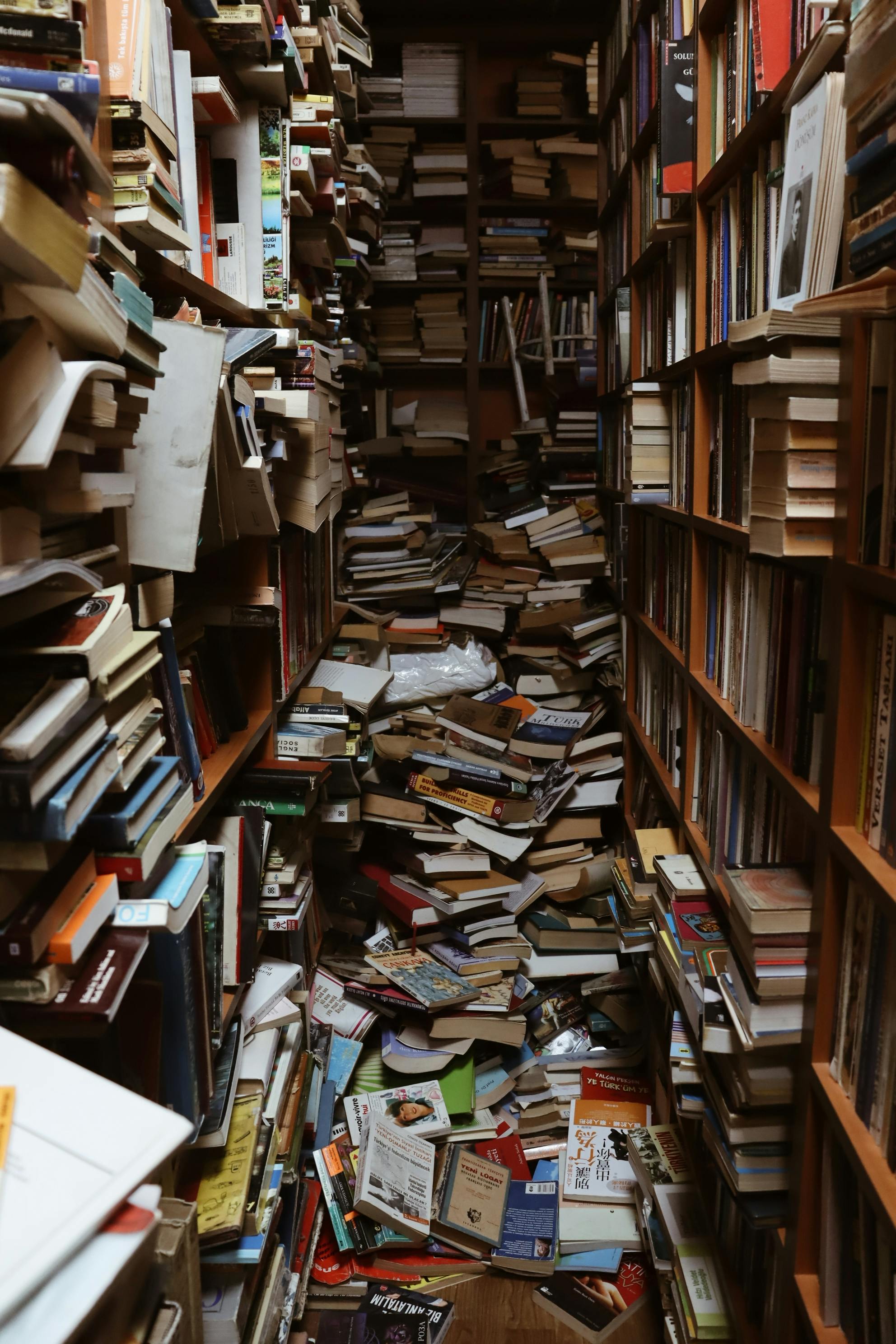 scattered books between bookshelves