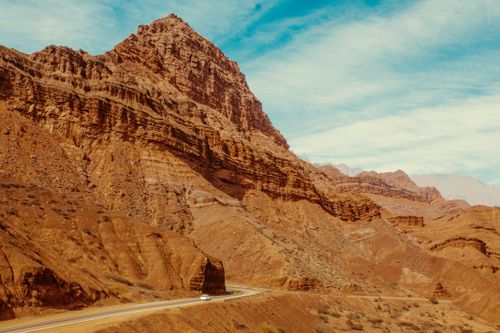 Free A scenic road winds through a massive desert canyon under a clear blue sky. Stock Photo