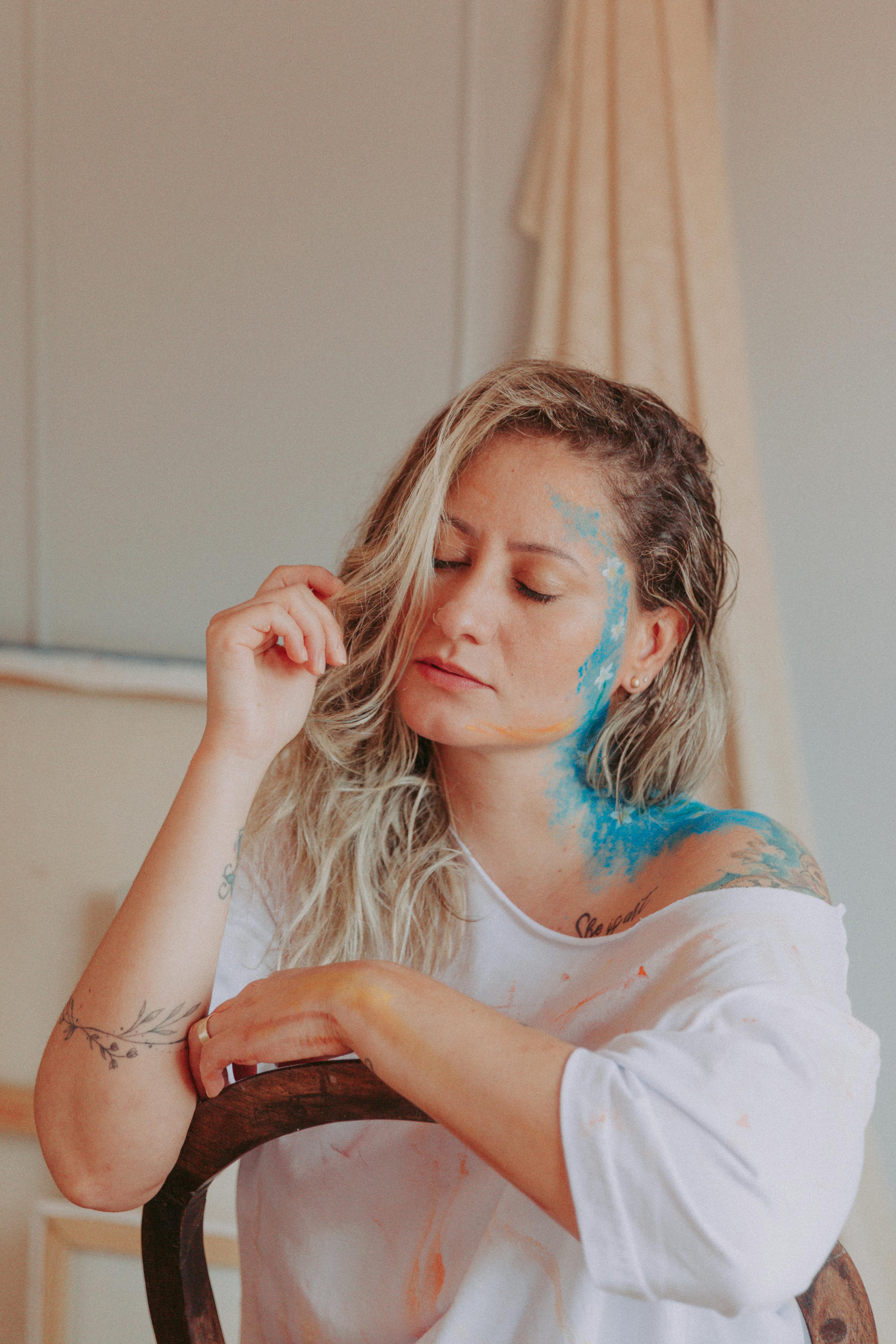 A serene portrait capturing a woman with artistic face paint, embodying creativity and tranquility.