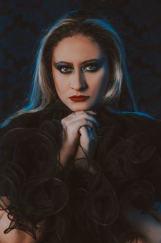 Moody portrait of a woman with bold makeup and dramatic lighting.
