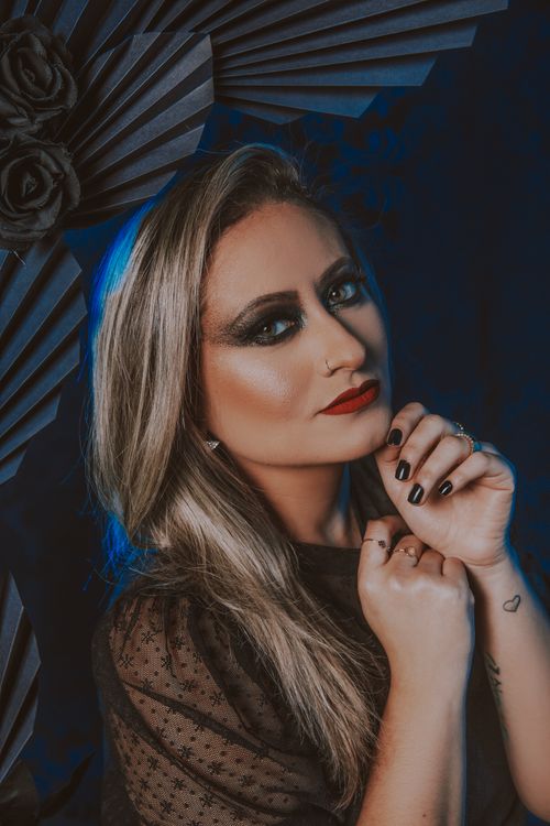 Free A stylish portrait of a woman with dramatic smoky makeup and blonde hair in an artistic setting. Stock Photo
