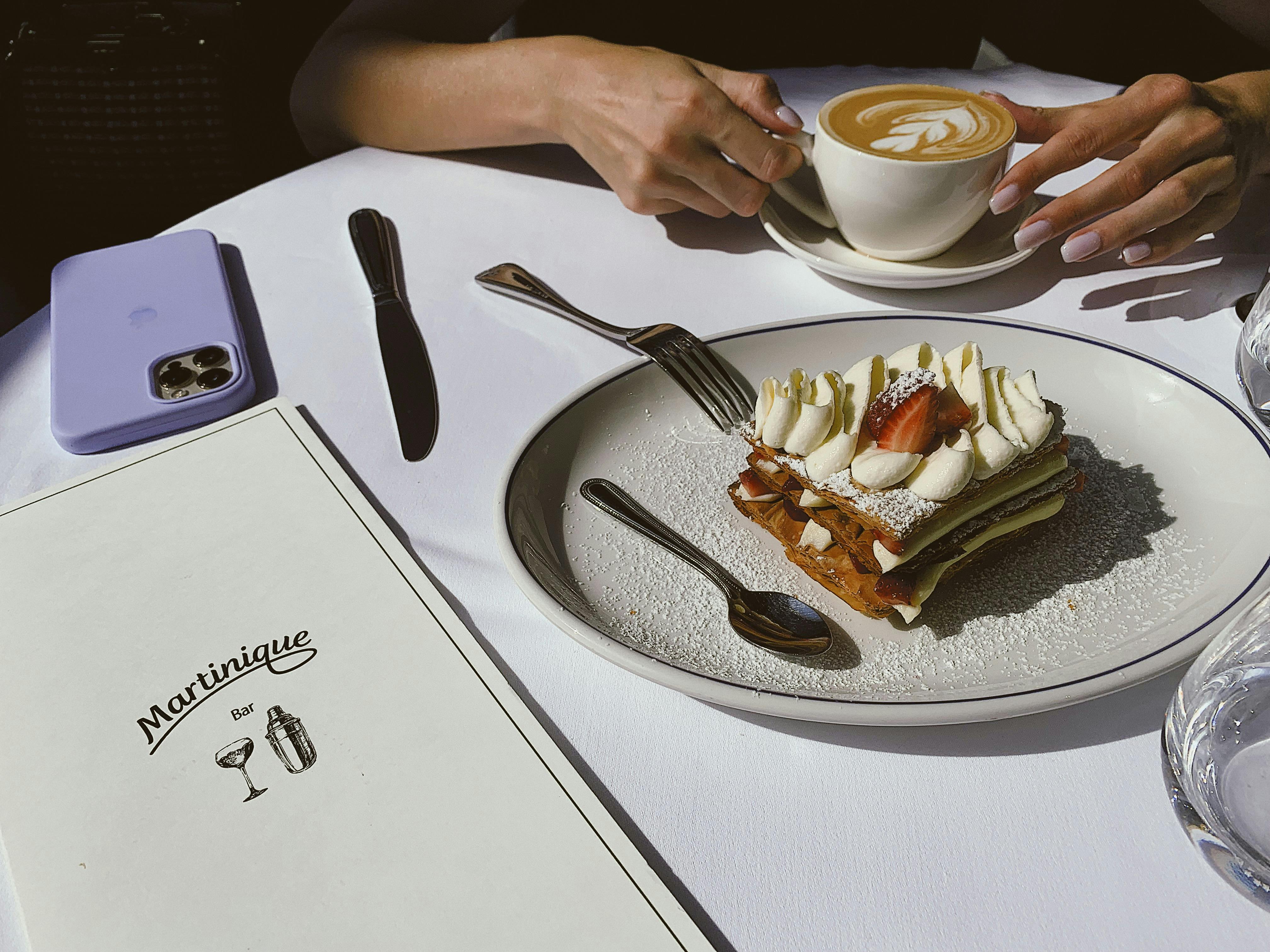A delicious mille-feuille dessert with coffee at a cafe, perfect for a relaxing moment.