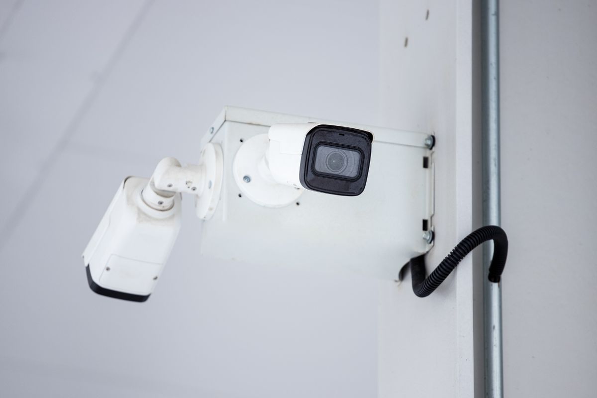 Kamera CCTV terpasang di dinding gedung menggambarkan tantangan eksplorasi rute alternatif misi stealth