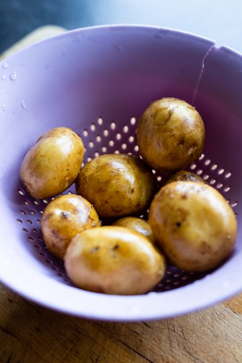 Free Close-up of fresh potatoes in a purple strainer, prepped for cooking. Stock Photo