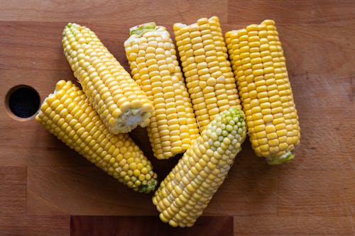 Free Yellow Corn Cobs on Wooden Surface Stock Photo