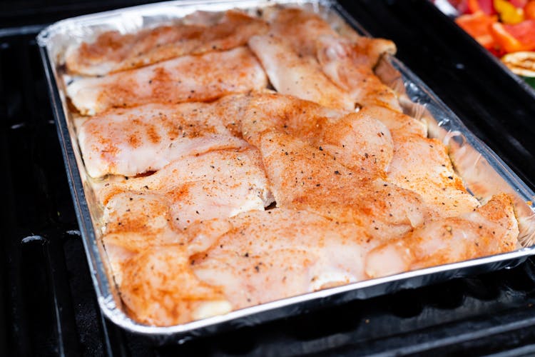 Seasoned Chicken Breasts And Thighs On Aluminum Tray