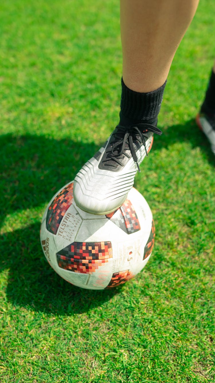 A Person Stepping On A Soccer Ball