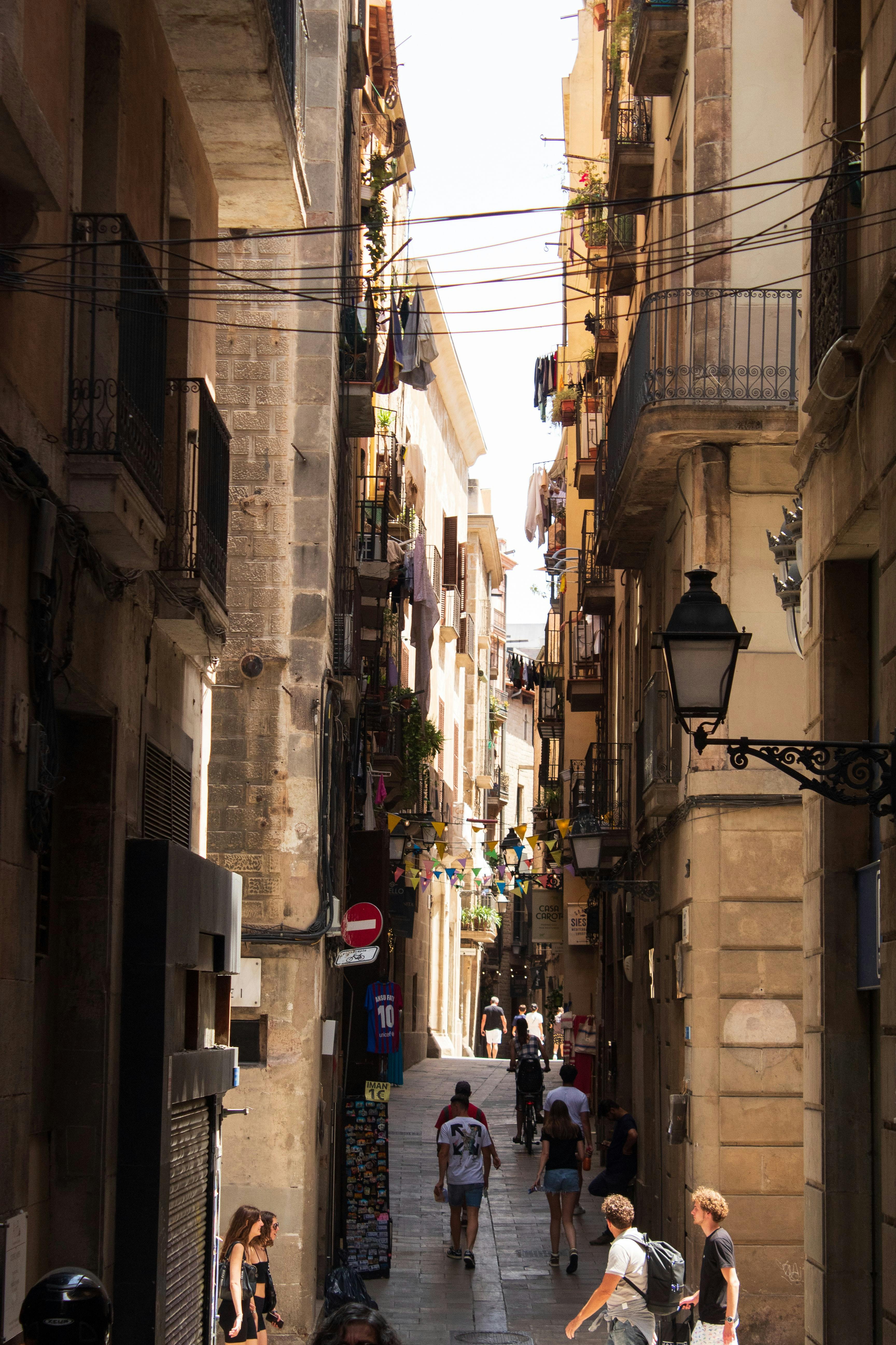 people walking in an alley between old buildings