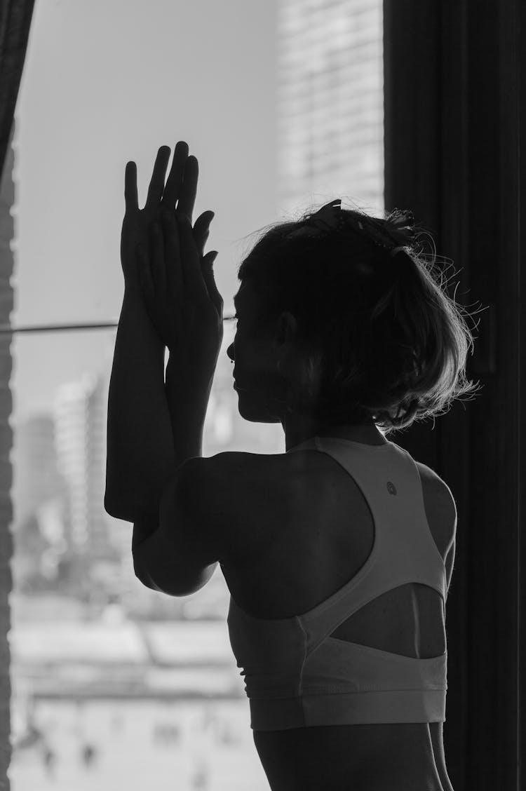 Woman Touching And Looking Through Window