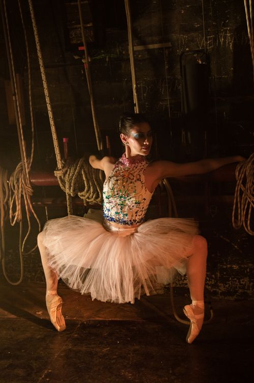 Free Ballerina striking a pose in an atmospheric backstage setting, showcasing grace and artistic expression. Stock Photo