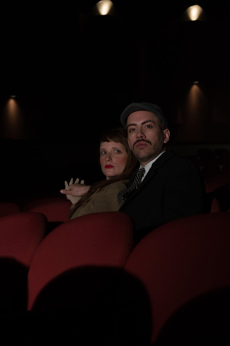 Man And Woman Sitting On Theatre Seats 