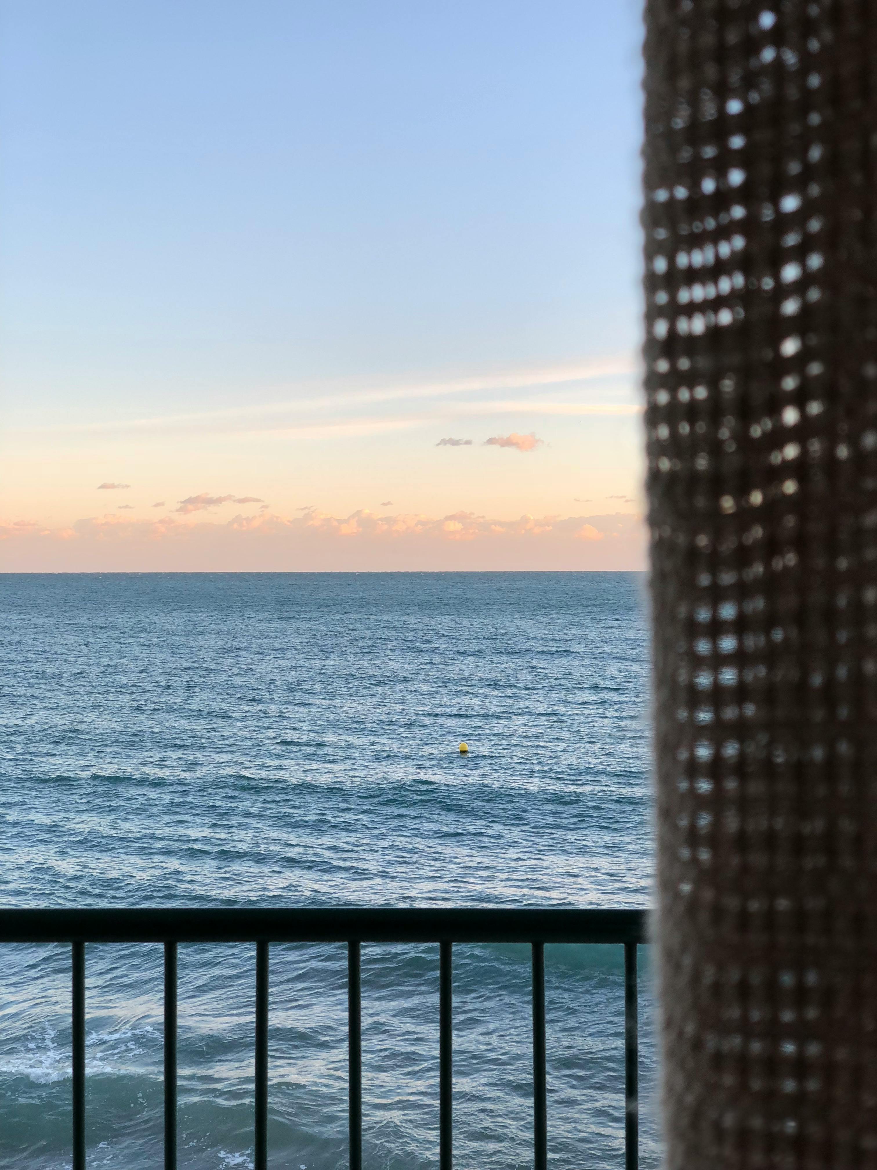 日落时阳台上宁静的海洋景观，非常适合休闲主题