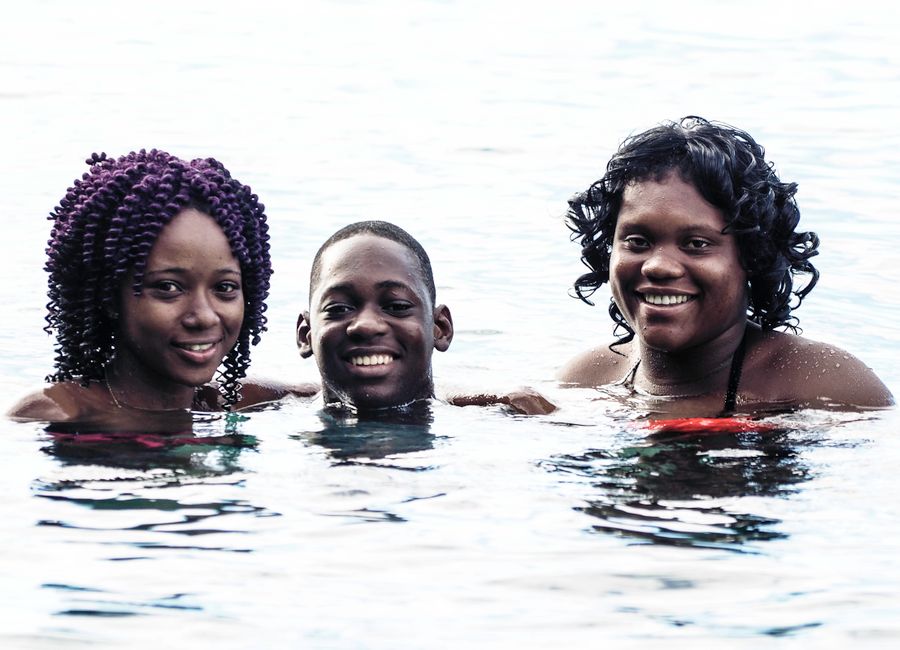 Three friends enjoying a refreshing swim in Buccament, St. Vincent under the sun.