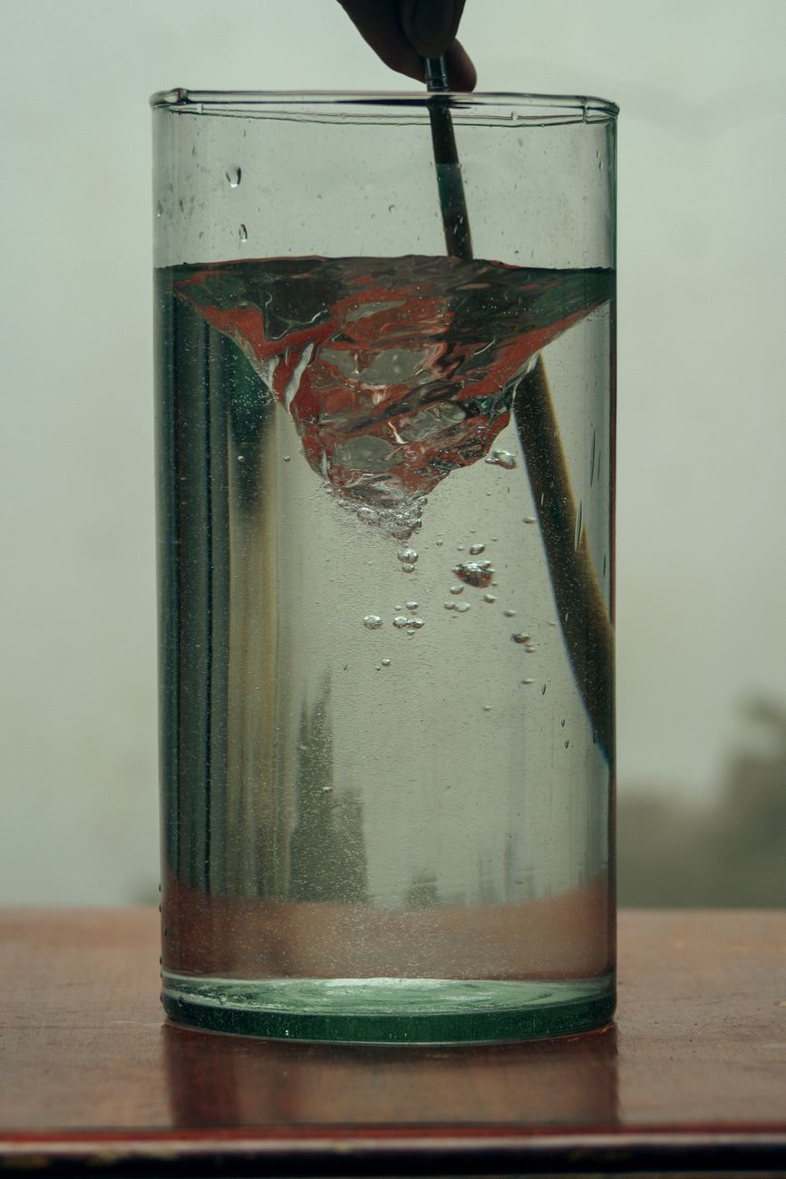 Close-up of a stirring water vortex in a glass, creating a dynamic visual effect.