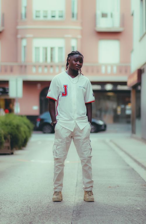 Free Young man in stylish outfit posing confidently on a city street. Stock Photo