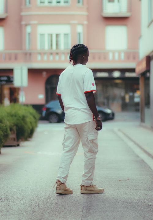 Free Back view of a stylish man in casual fashion outfit walking on an urban street during the day. Stock Photo