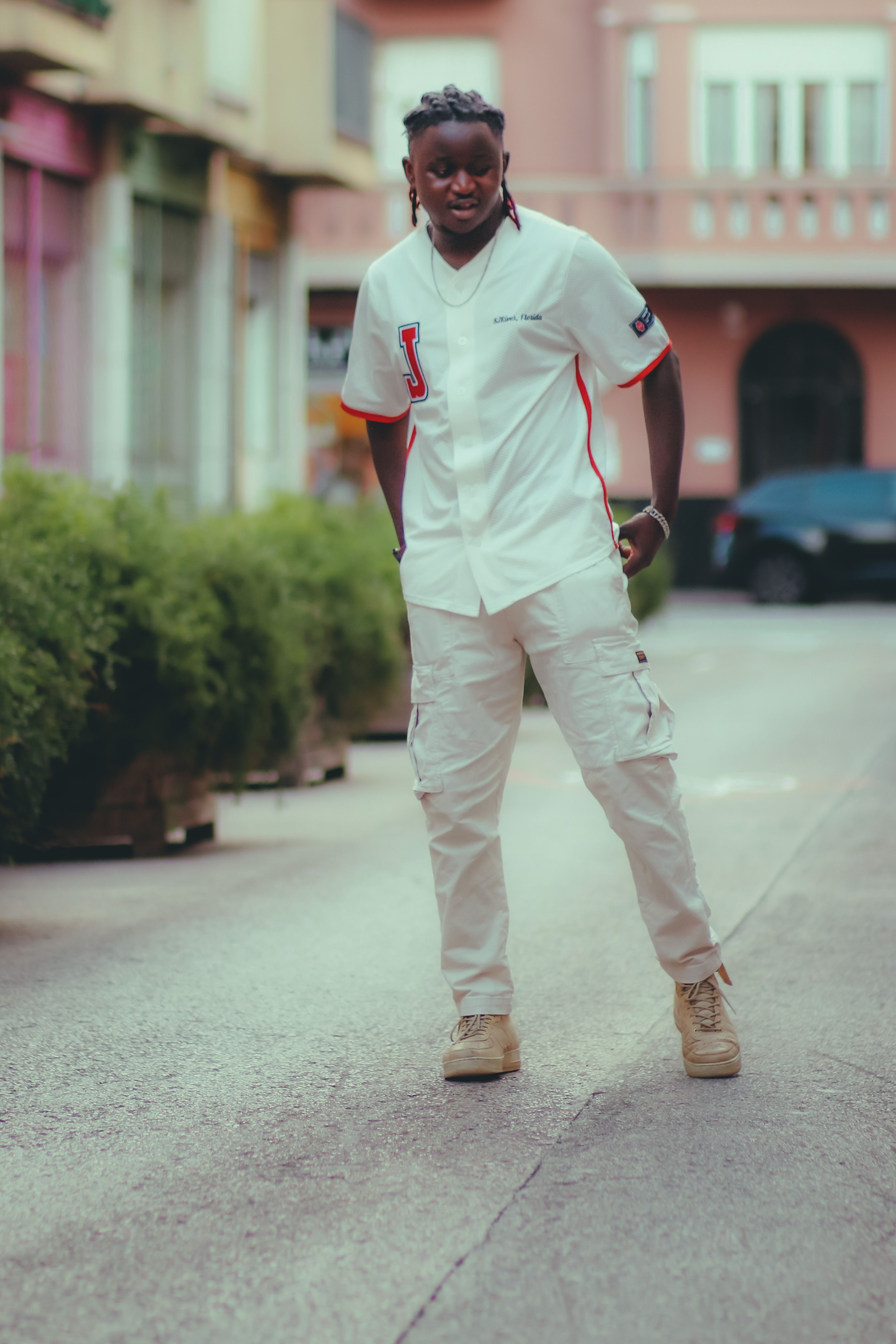Stylish young man in white outfit showcasing urban street style.