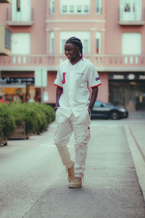 Free A fashionable adult male walking down a stylish urban street, showcasing modern street style. Stock Photo