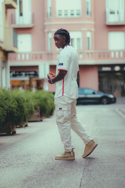 Free Full body shot of a stylish man in urban street fashion walking through a city street. Stock Photo