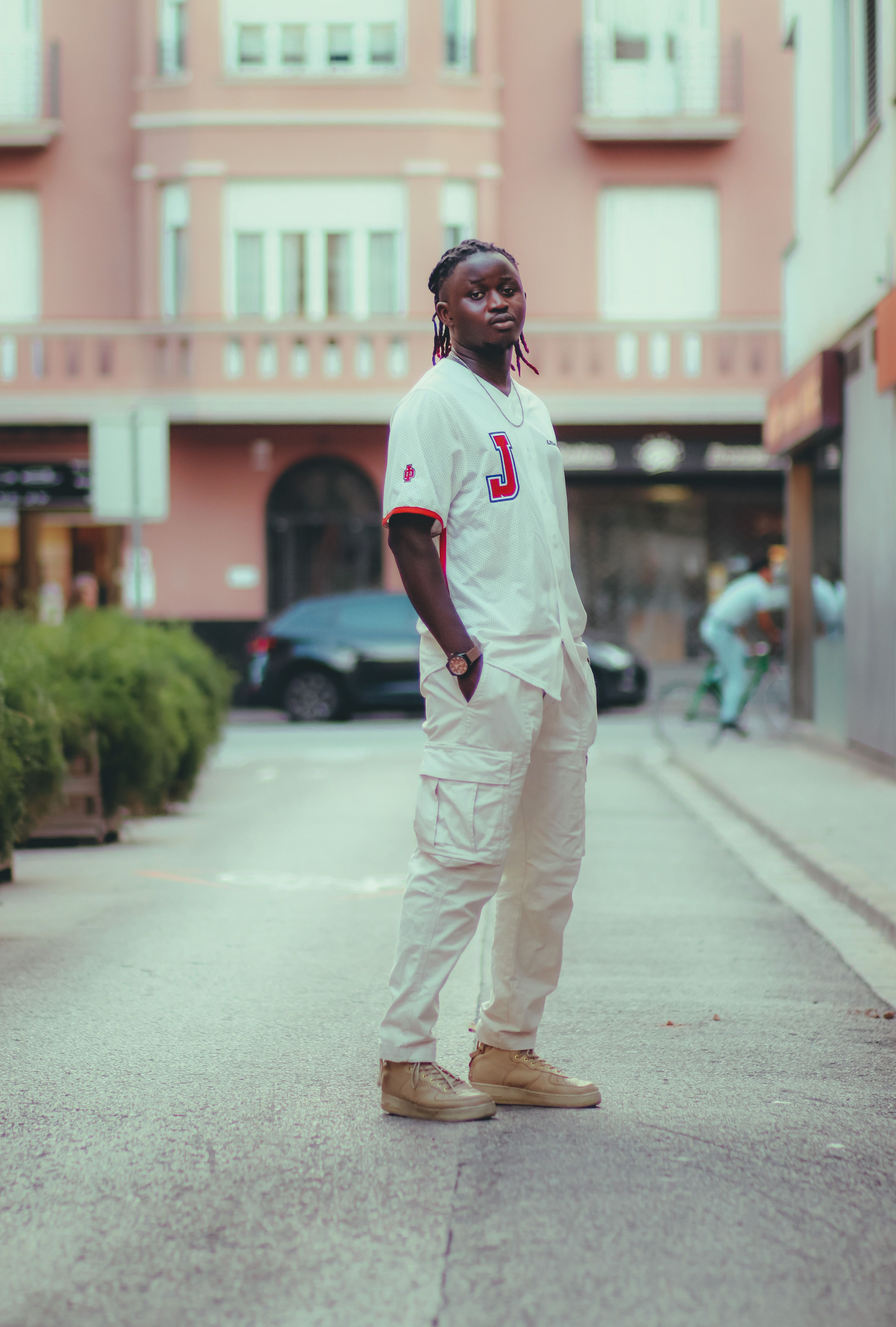 Full shot of a fashionable person in urban street style, standing in an outdoor setting.