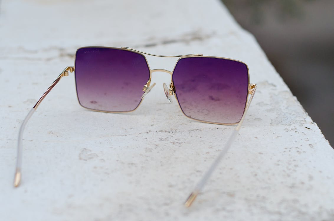 Gold-colored Framed Purple Lens Sunglasses on Gray Surface