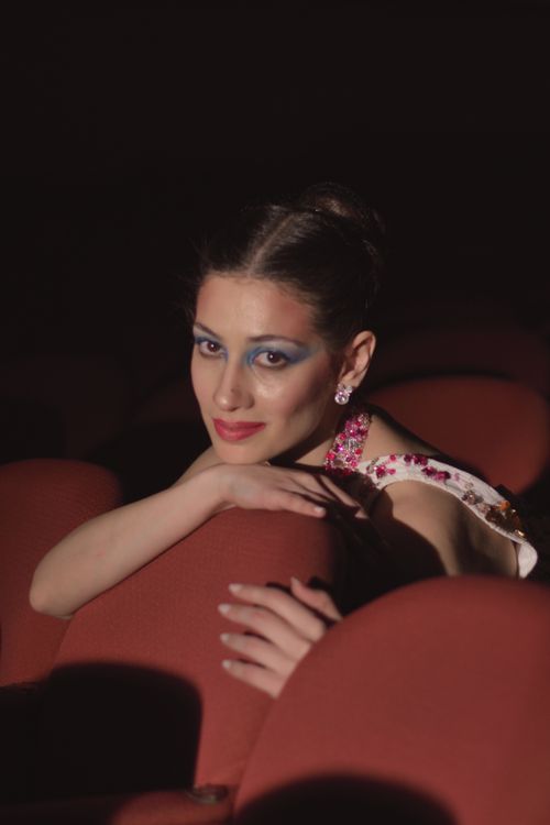 Free Stunning woman posing elegantly in theater seating, exuding beauty and grace. Stock Photo