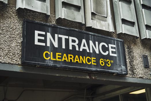Close-up of an entrance clearance sign on a building, indicating height limit.