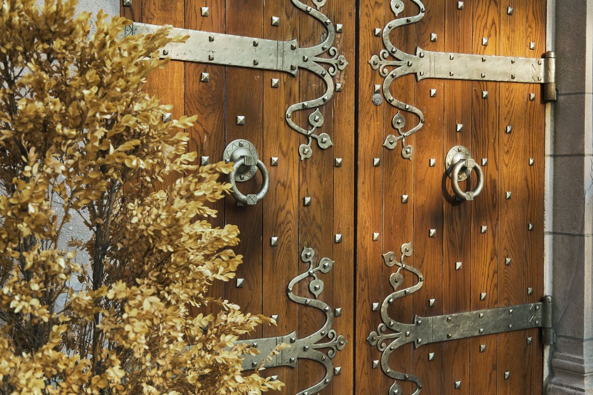 Close-up of a wooden door with iron hardware