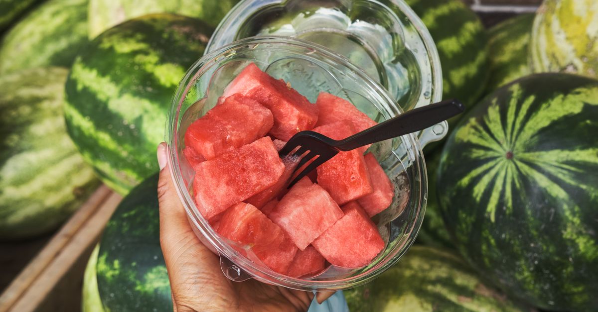 Close-up of hand holding a bowl of sliced watermelon with a fork. Juicy and delicious summer fruit. - Evidence evidence guide for watermelon hydration exercise meta-analysis