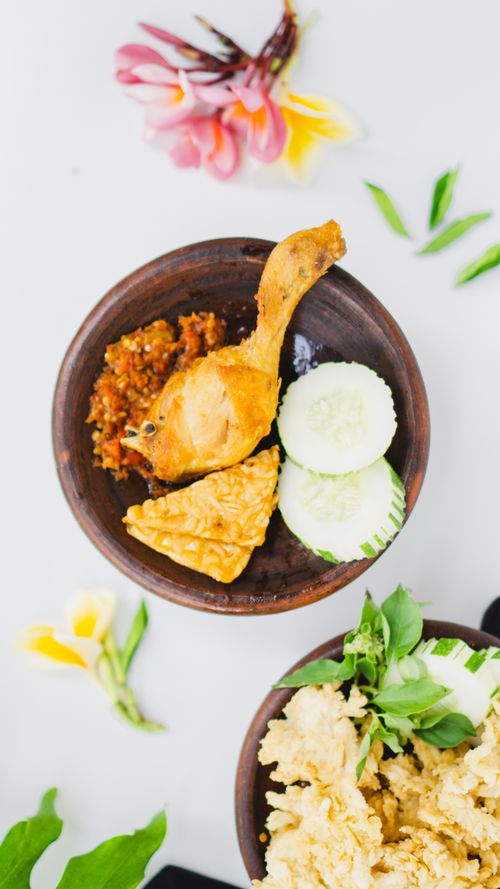 Free Top view of Indonesian chicken with sambal and fresh vegetables on a bowl. Stock Photo