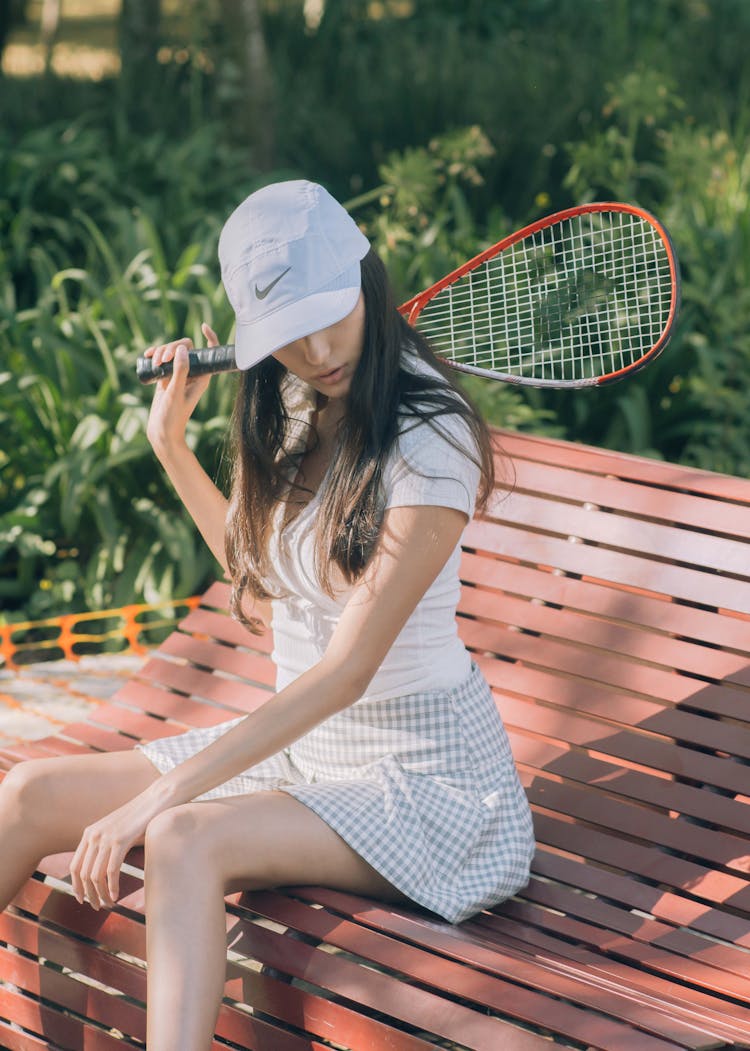 A Tennis Player Sitting On A Bench 