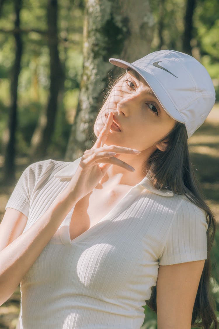 A Woman In White Top With Finger On Lips