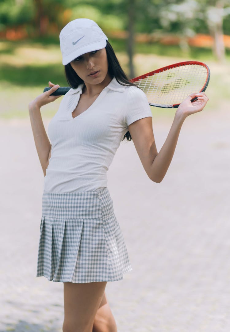 A Tennis Player Wearing A Skirt And Cap