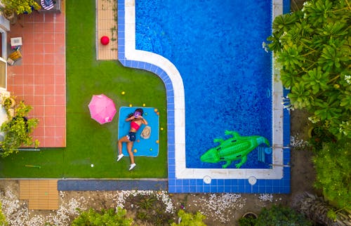 Femme Allongée Sur Un Tapis Bleu à Côté D'une Piscine