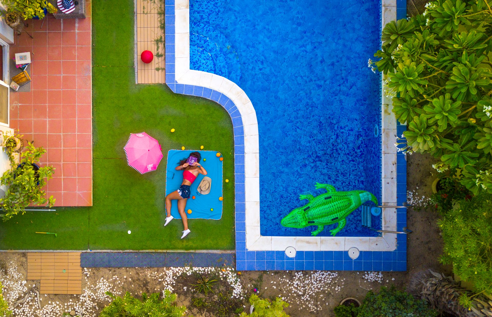 Woman Lying on Blue Mat Beside a Pool