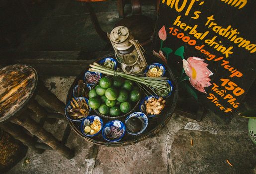 An overhead view of traditional herbal drink ingredients displayed on a street table, capturing vibrant textures and colors.