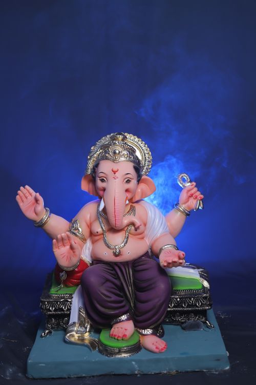 Free A detailed Ganesha figurine with mystical blue smoke background, symbolizing Hindu spirituality. Stock Photo