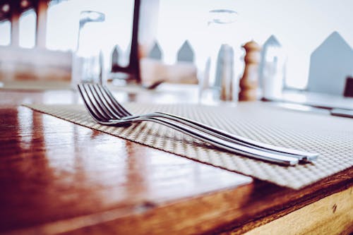 Free Two Stainless Steel Forks on Top of Place Mat Stock Photo