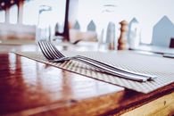 Two Stainless Steel Forks on Top of Place Mat