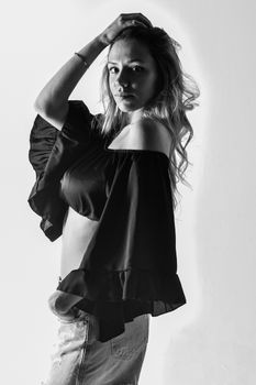 Black and white portrait of a woman posing elegantly in a fashionable blouse.