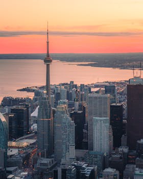 A breathtaking aerial view of Toronto's iconic skyline featuring the CN Tower at sunrise.