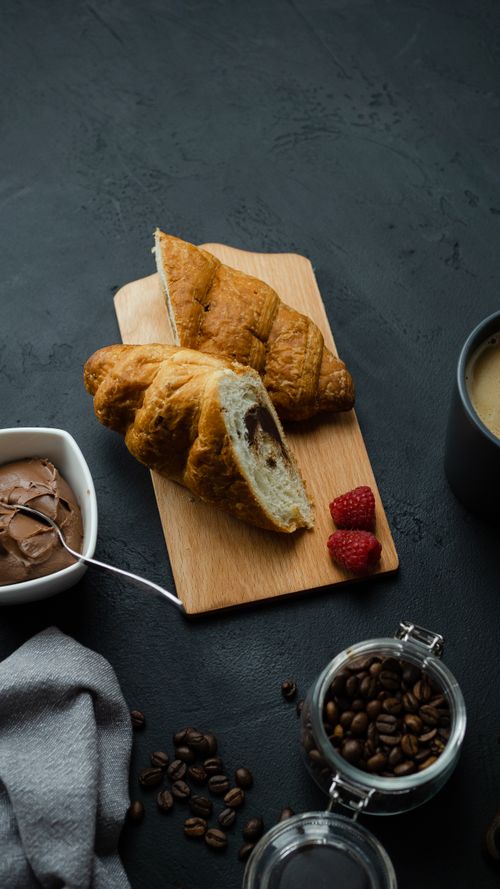 Free Delicious croissants on a wooden board with coffee and chocolate spread for breakfast. Stock Photo