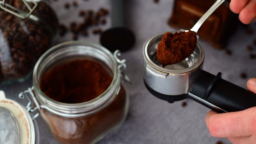 Spoon with Coffee Beside a Jar