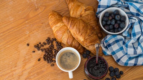 Free Cup of Coffee next to Croissants and Blueberry Jam Stock Photo